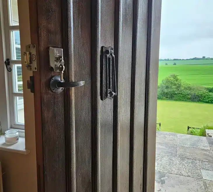 Old door with locks and in background farm fields