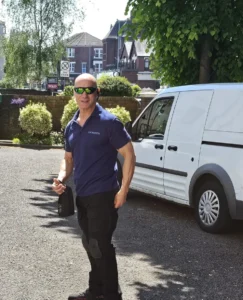 Locksmith Ivo with blue polo shirt and black pants in from of white van